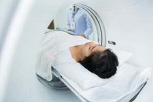 women entering a CT machine for a brain scan.