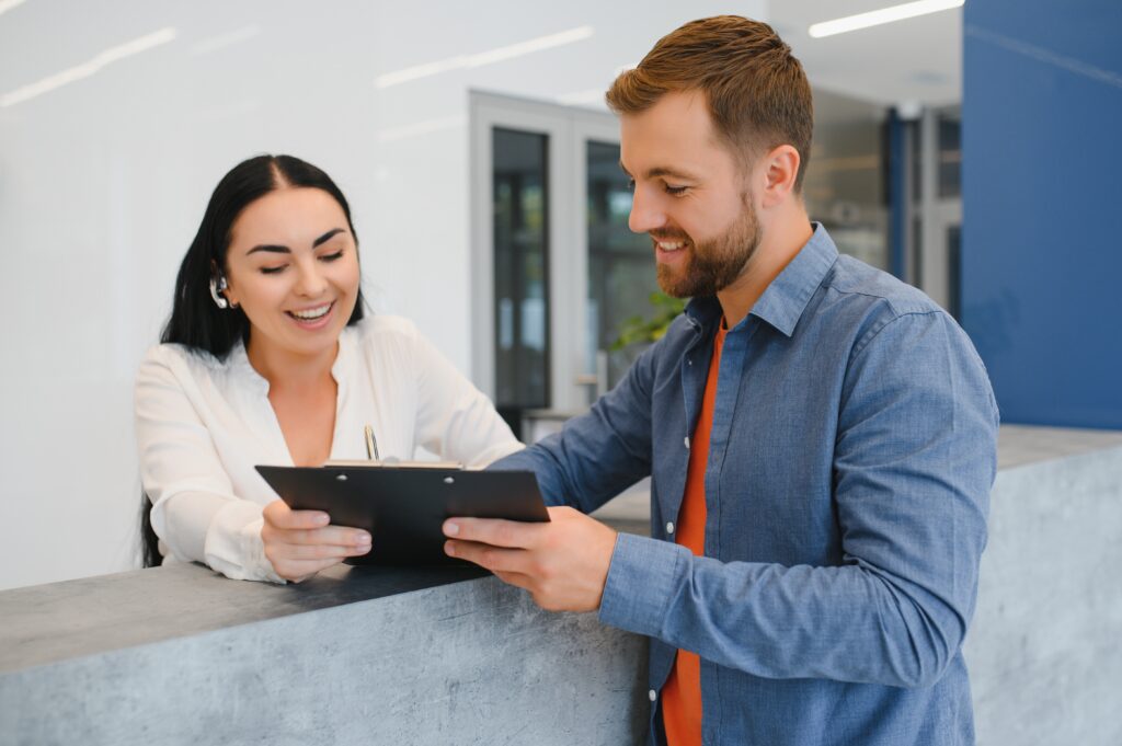 Receptionist checking in patient at desk