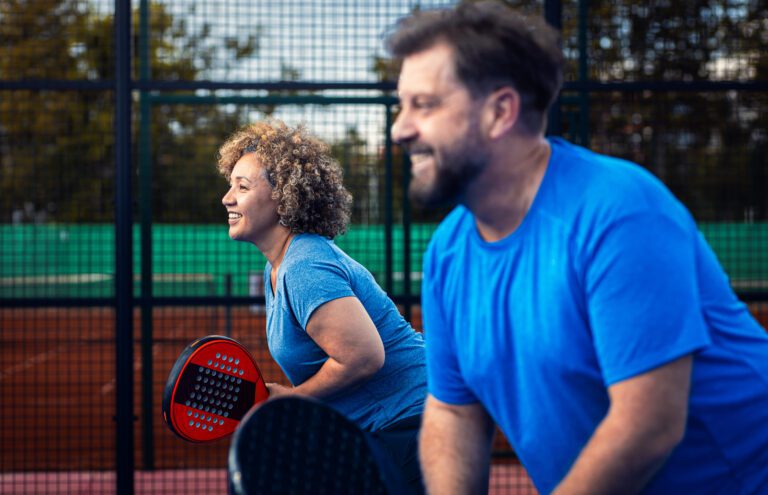 Two active adults playing pickleball